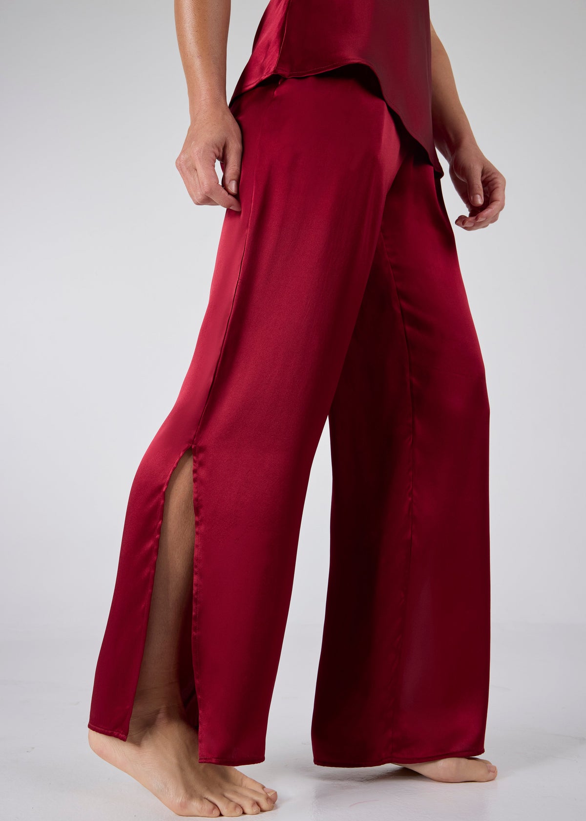 Close-up of high-slit wide-leg pants from A.ROSE Juliet Set in dark red washable silk – elegant detail that adds movement and ease to luxury loungewear and/or sleepwear.