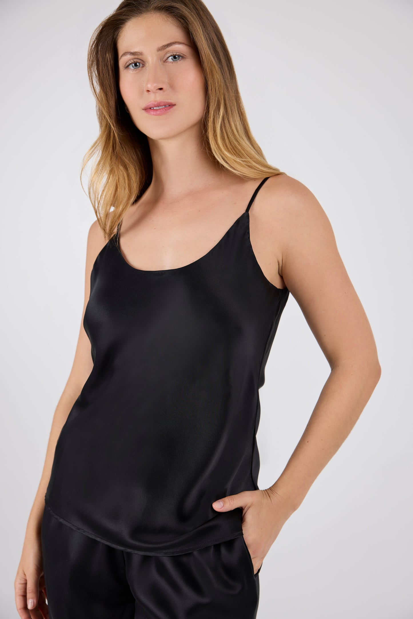 Model wearing A.ROSE Juliet Set in black washable silk – elegant two-piece lounge set featuring an adjustable spaghetti strap tank and high-slit wide-leg pants with a soft, stretchy waistband and side pockets. Designed for comfort and sophistication.