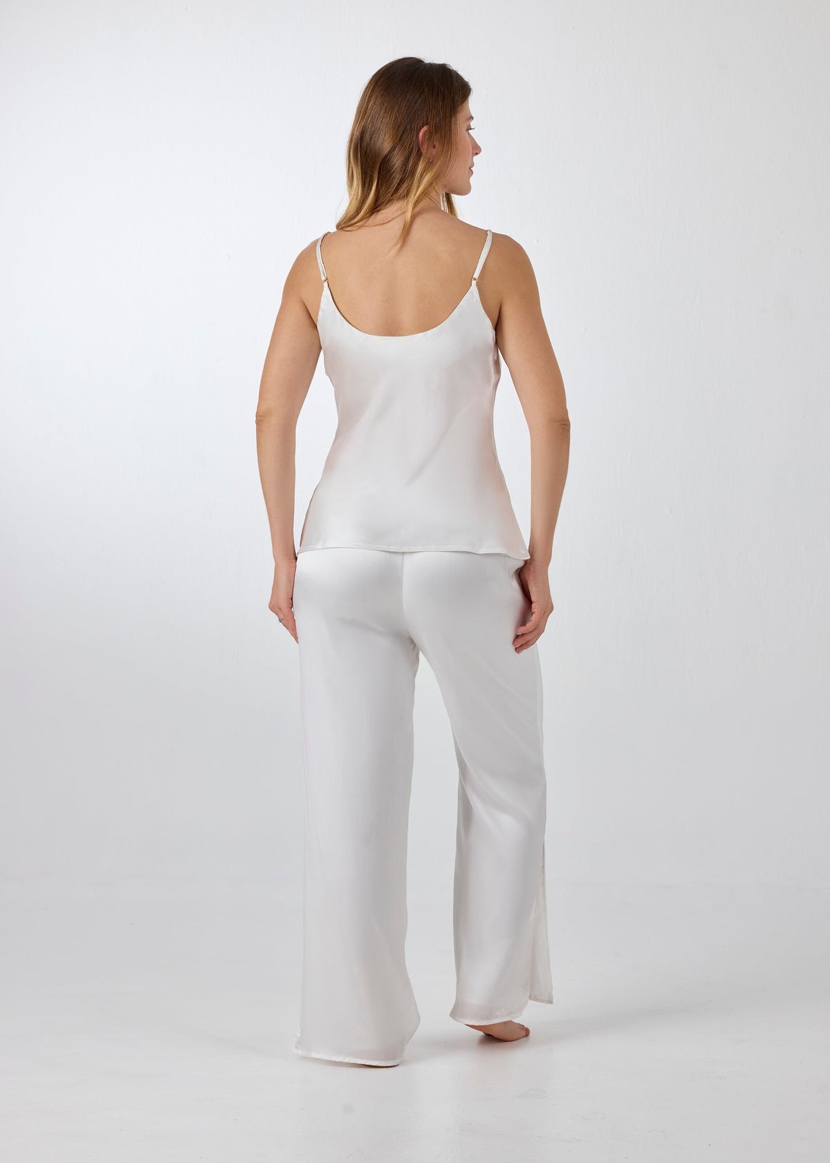 Back view of model wearing A.ROSE Juliet Set in ivory washable silk – elegant two-piece lounge set and/or pajama set with an adjustable spaghetti strap tank and high-slit wide-leg pants. Designed for bridal moments, getting ready, gifting, or everyday luxury.