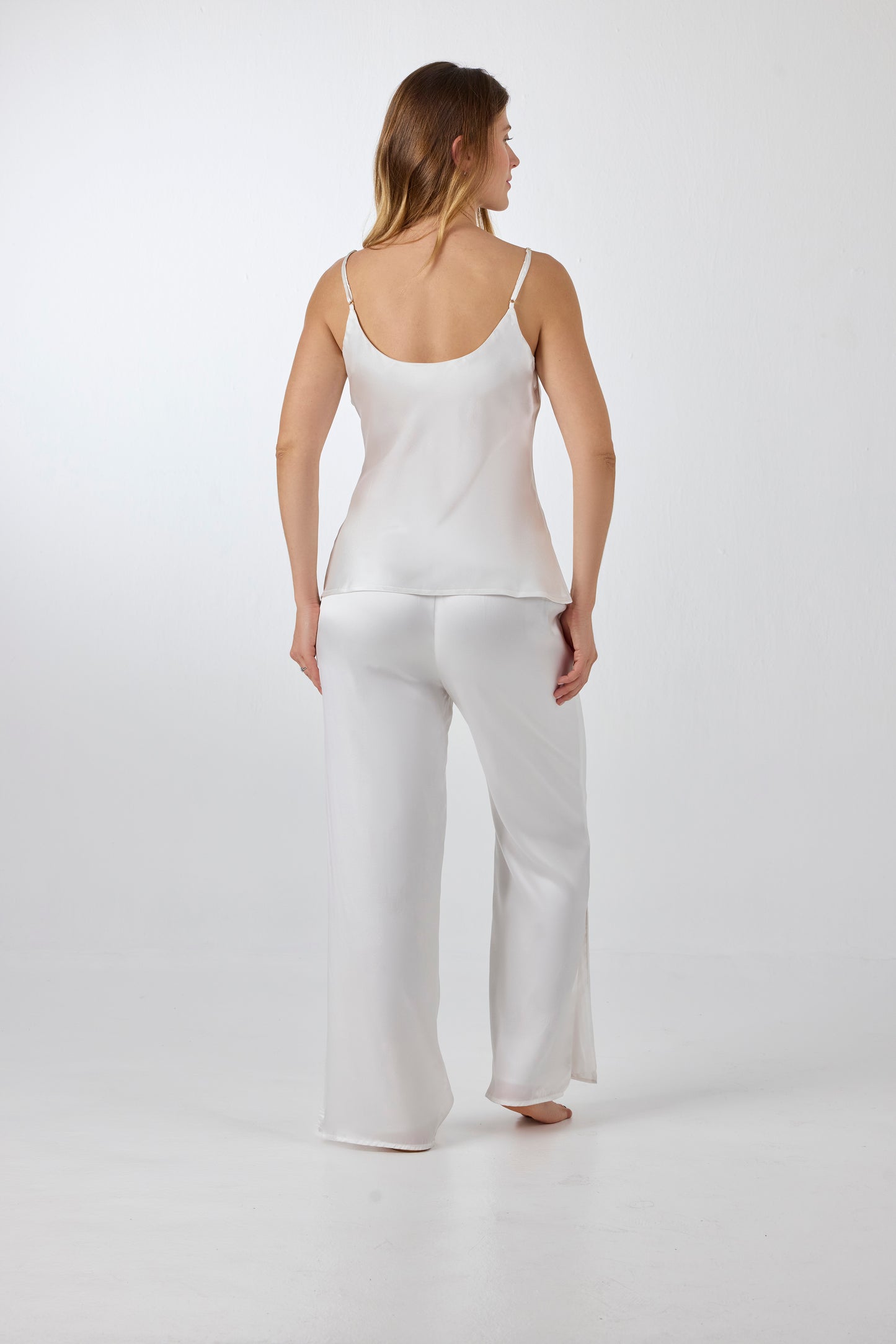 Back view of model wearing A.ROSE Juliet Set in ivory washable silk – elegant two-piece lounge set and/or pajama set with an adjustable spaghetti strap tank and high-slit wide-leg pants. Designed for bridal moments, getting ready, gifting, or everyday luxury.